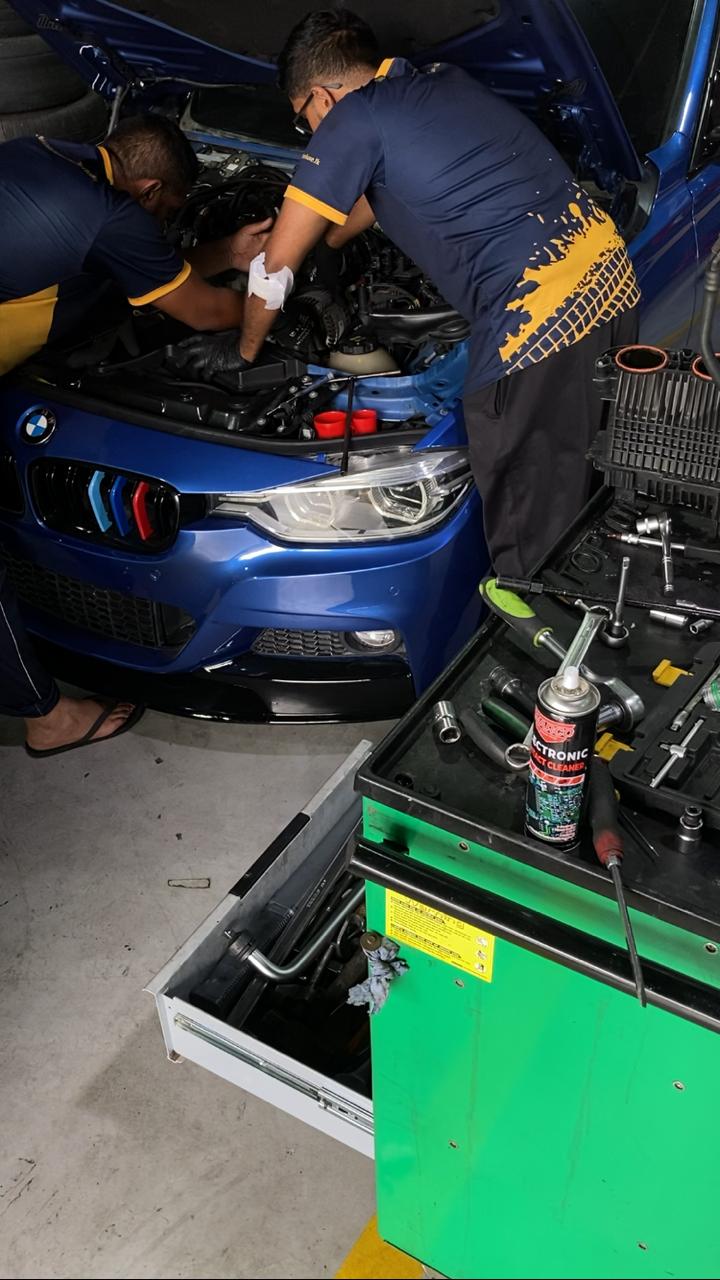 Technician working on a BMW engine bay